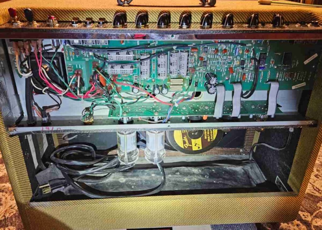 Roland Cube 60 stage with cans and bottles — Cube 60 on worn stage floor with scattered beer cans and liquor bottles nearby; background stage haze and truss visible.