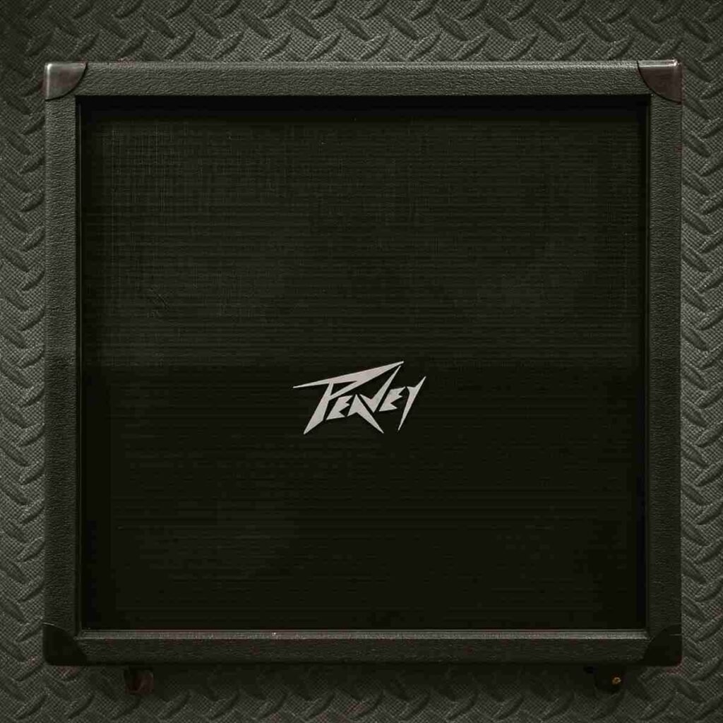 Peavey Front View — Peavey 4×12 stack front view showing black grille cloth and logo, amp sitting on a worn stage floor.