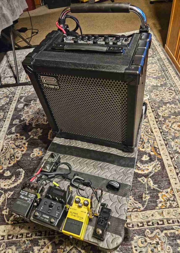 Roland Cube 60 — Original photo — Front view of a Roland Cube 60 on a patterned rug showing metal honeycomb grille and Roland logo at top left.